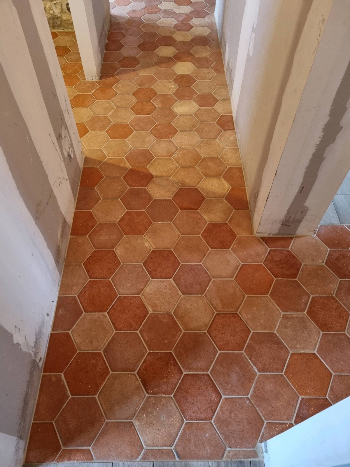 Pose de tomettes hexagonales en terre cuite dans une grange en rénovation proche Etretat